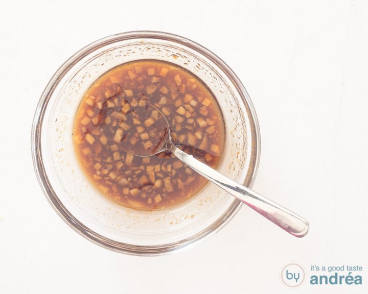 A glass bowl with a sauce with soy sauce, honey, garlic, ginger, chili sauce and sesame oil