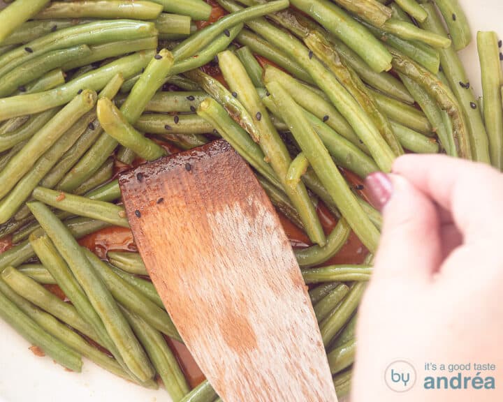 A white frying pan with baked beans, sesame seeds are sprinkled on top