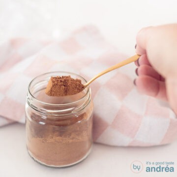 A square photo with a glass jar with a spoon showing gingerbread spices.