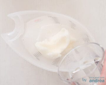 A scoop of lemon ice cream with 7up poured on a white surface
