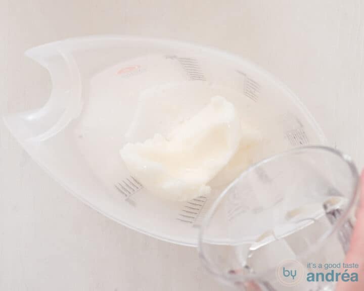 A scoop of lemon ice cream with 7up poured on a white surface