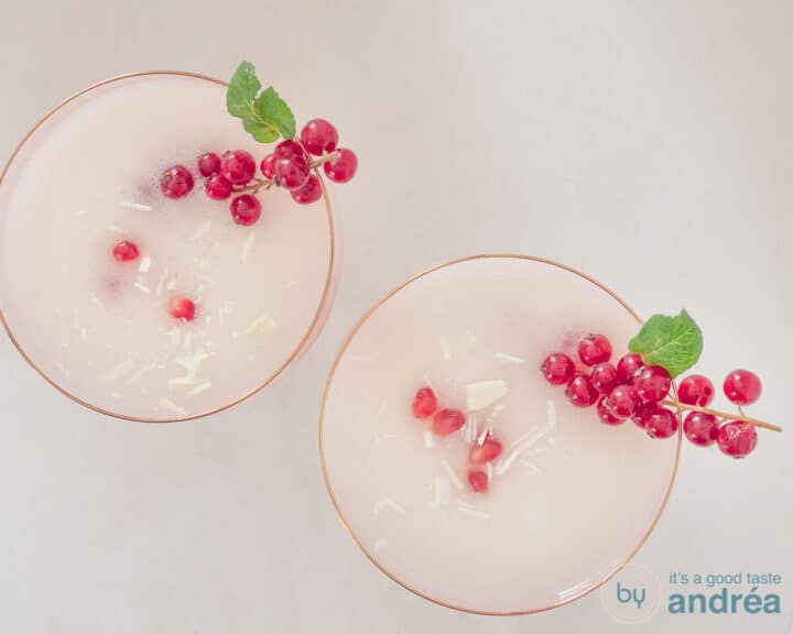 Two glasses filled with scroppino and garnished with berries, mint, chocolate and pomegranate seeds