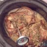 Roast beef in the slow cooker with a meat thermometer inserted.