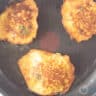 Corn fritters are fried in a skillet until brown.