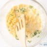 A bowl with Corn Fritter batter with corn and parsley