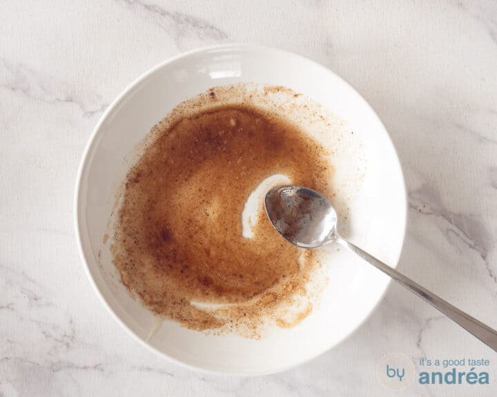 A pink plate with colored rainbow carrots, roasted on a white background.