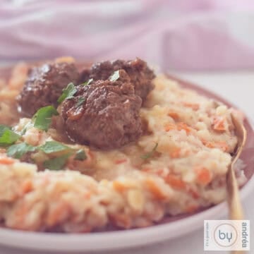 A square photo showing part of a plate of wortelstamppot with spicy meatballs.
