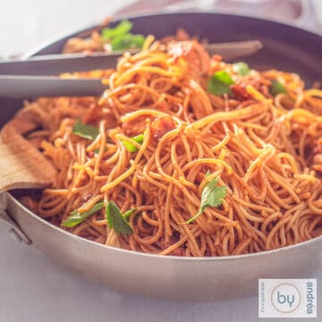 A square photo with a wok filled with Surinamese style Bami with chicken and celery.