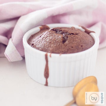 A white jar with molten chocolate in it. A pink white cloth in the background