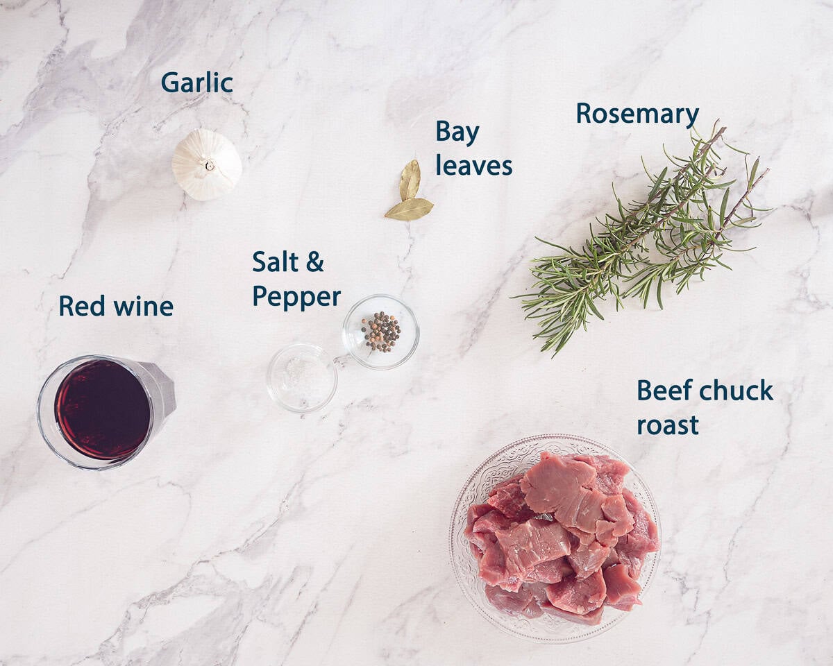 Ingredients Peposo- Italian Slow-Cooked Beef in Red Wine on a marble white background with text description