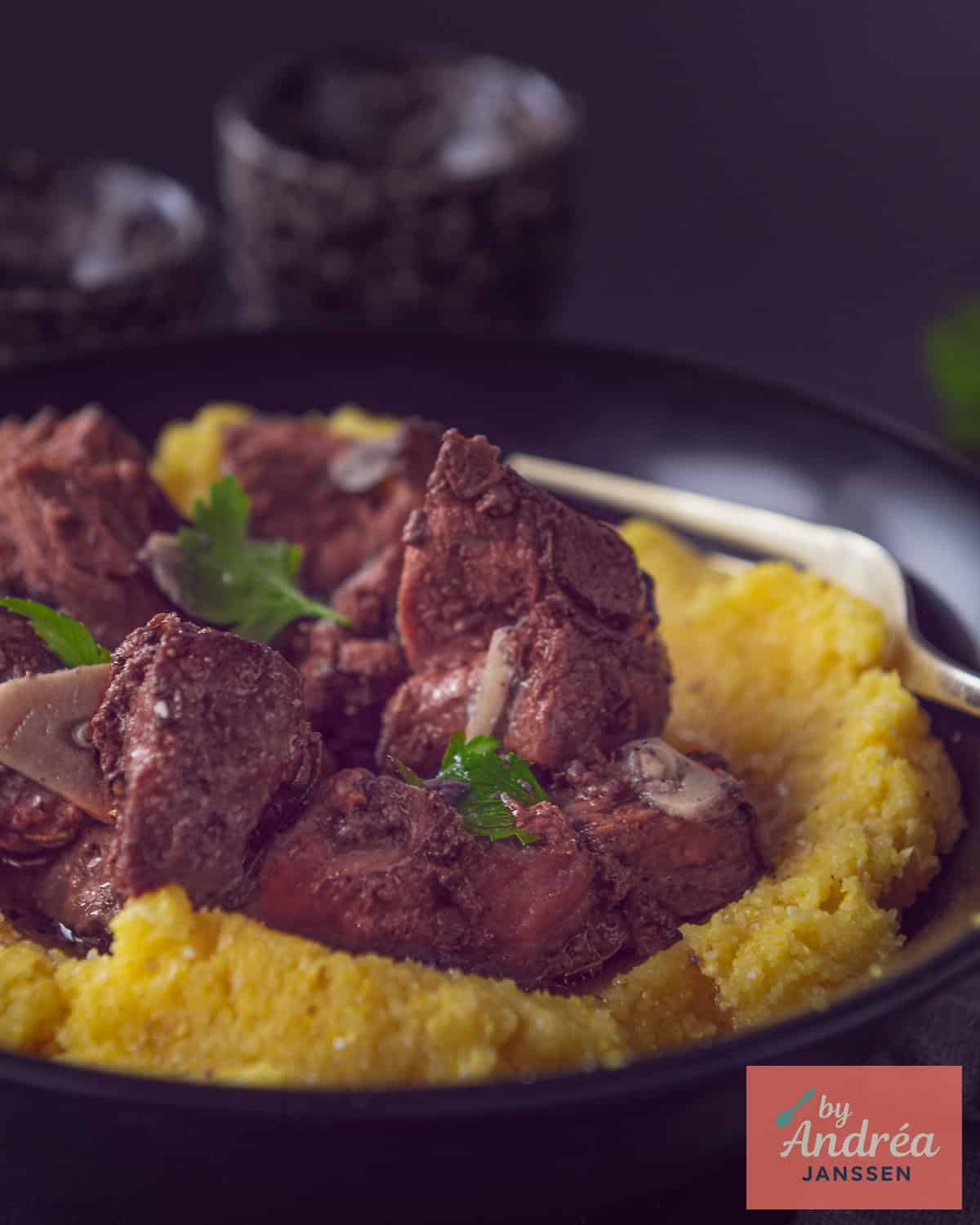 Peposo on a bed of polenta with a parsley garnish