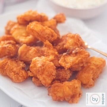 A square photo of a white bowl with kibbeling.