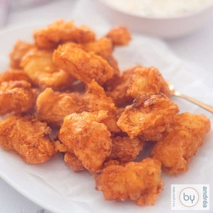 A square photo of a white bowl with kibbeling.