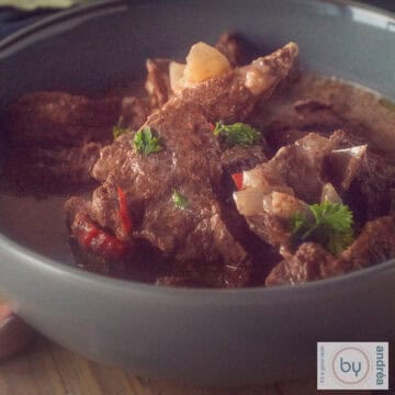 A square photo with a gray bowl of beef trinchado from the slow cooker.