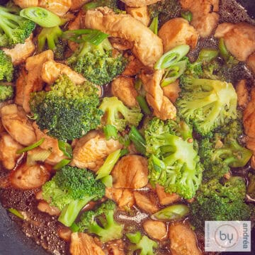 A square photo with a macro shot of chicken with broccoli in a sauce.