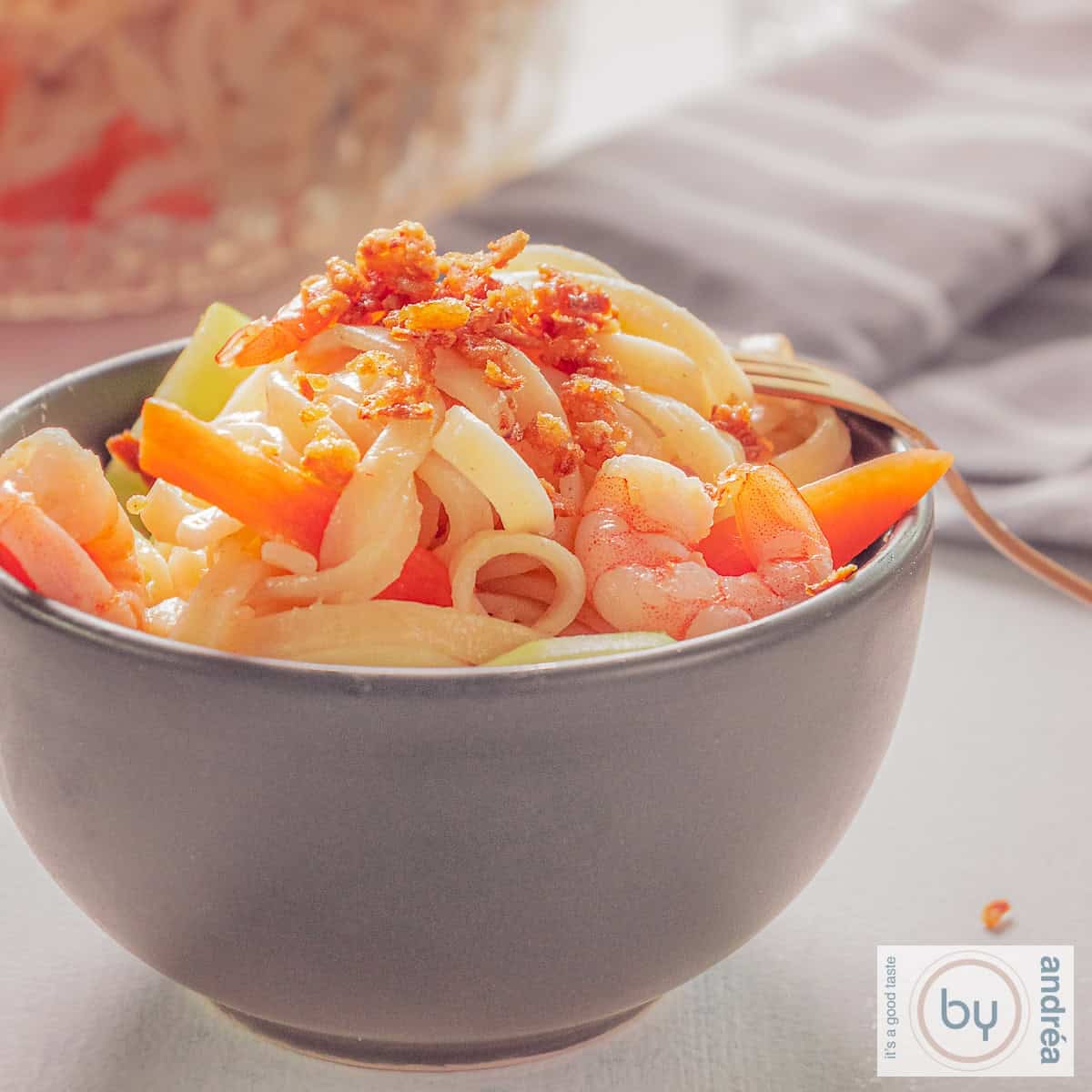 Een vierkante foto met een bamisalade met garnalen en groenten