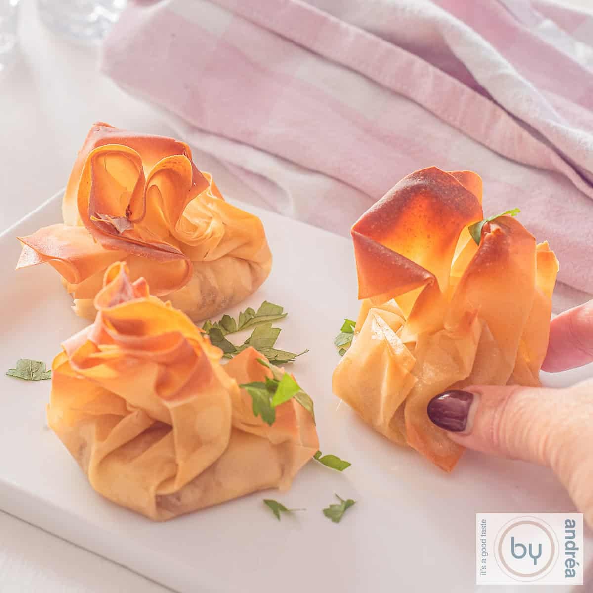 Een vierkante foto met drie geitenkaas hapjes met honing