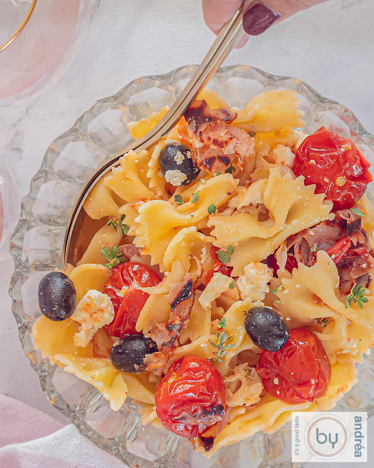 An overhead photo of pasta salad with feta, bacon and roasted tomatoes.