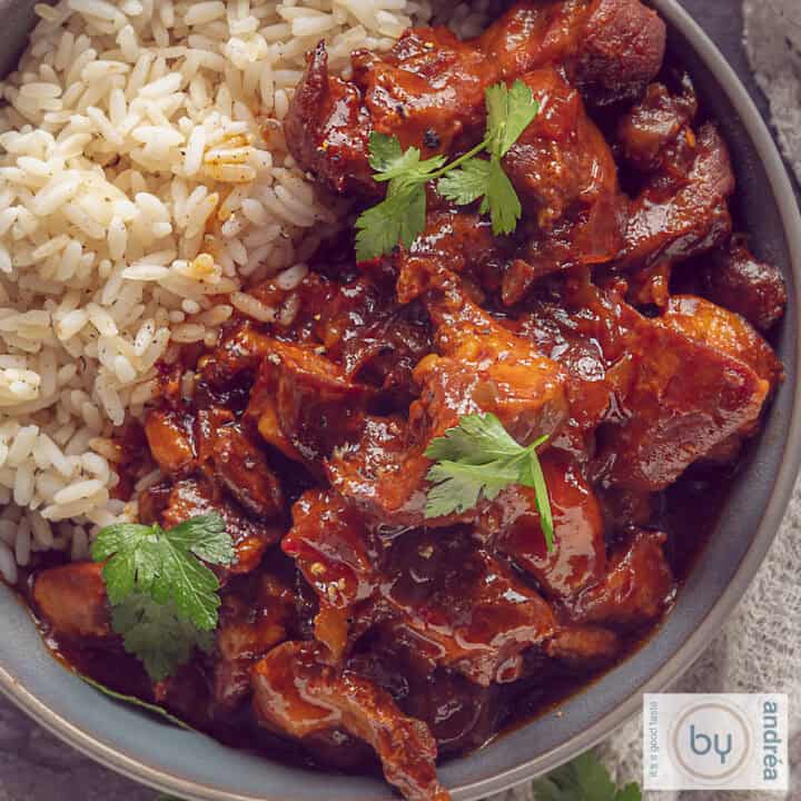 A square photo with a gray bowl with rice and ajam pangang.