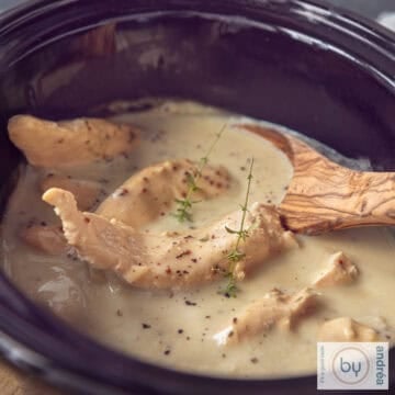 A square photo of a slow cooker filled with chicken and mustard sauce