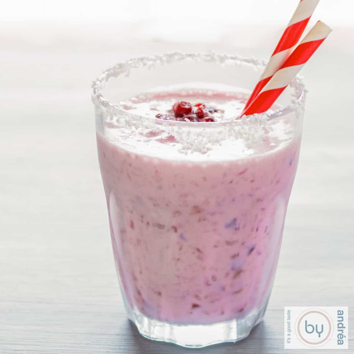 Granaatappel cranberry kokos smoothie op een grijze ondergrond