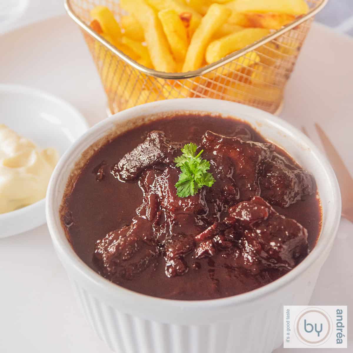 Een schaaltje met zuurvlees en frietjes en mayonaise