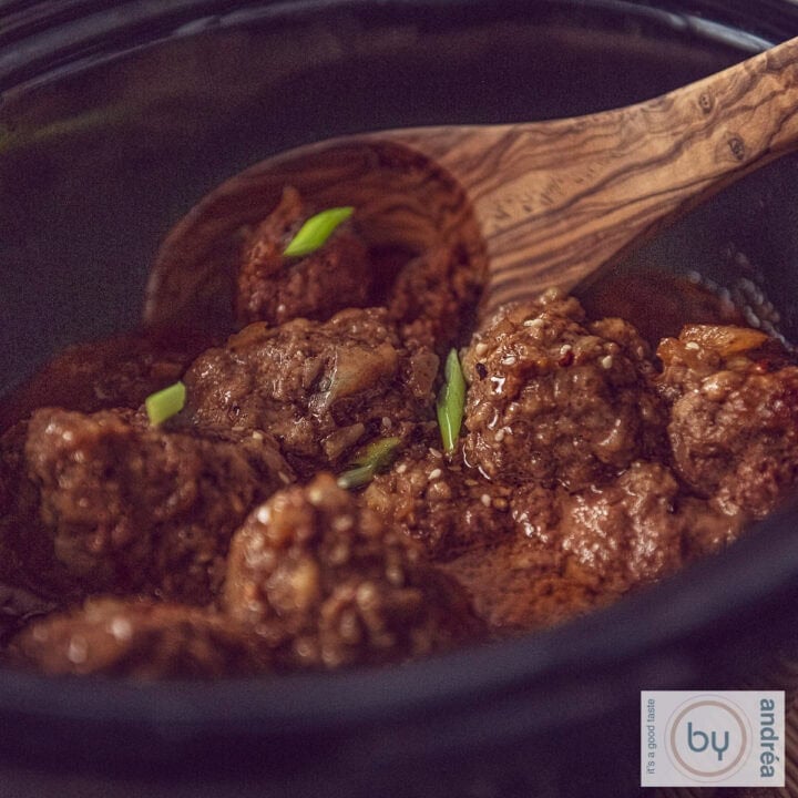 A square photo of a slow cooker filled with Indonesian meatballs in ketjap sauce