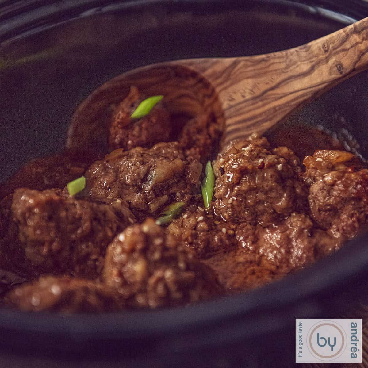 A square photo of a slow cooker filled with Indonesian meatballs in ketjap sauce