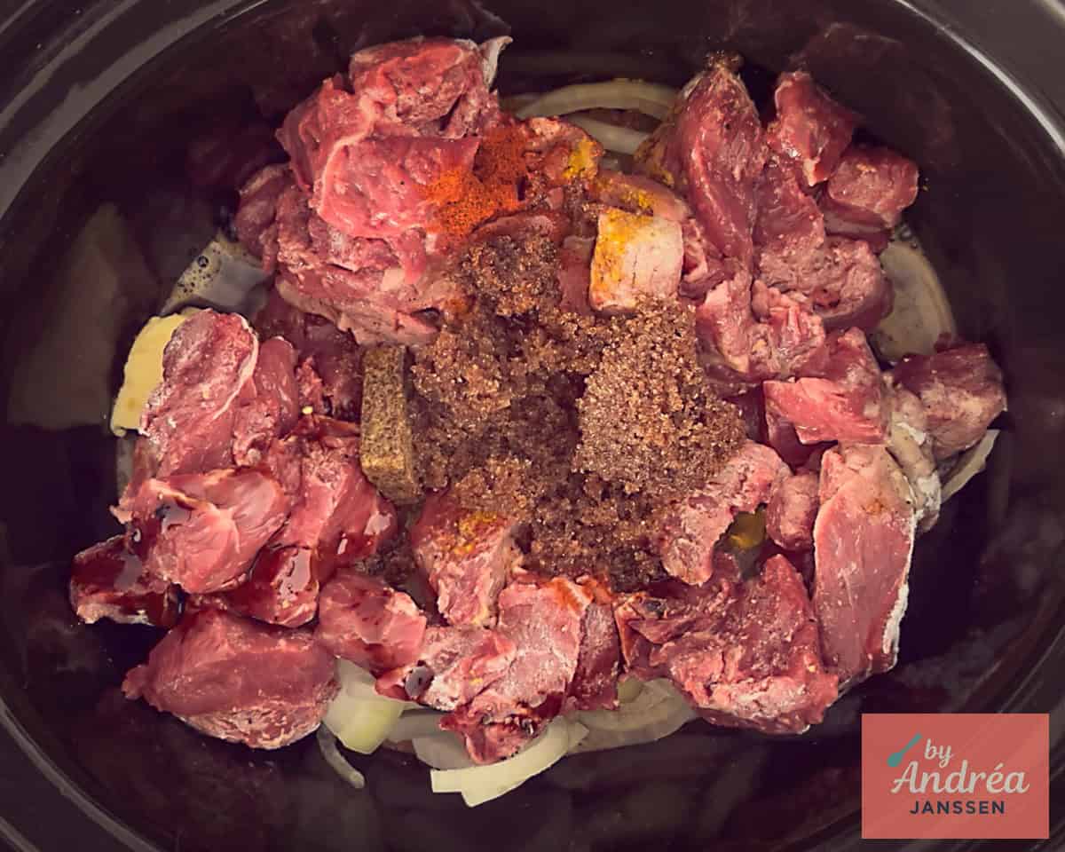 Onions, meat, garlic and other seasonings in the slow cooker