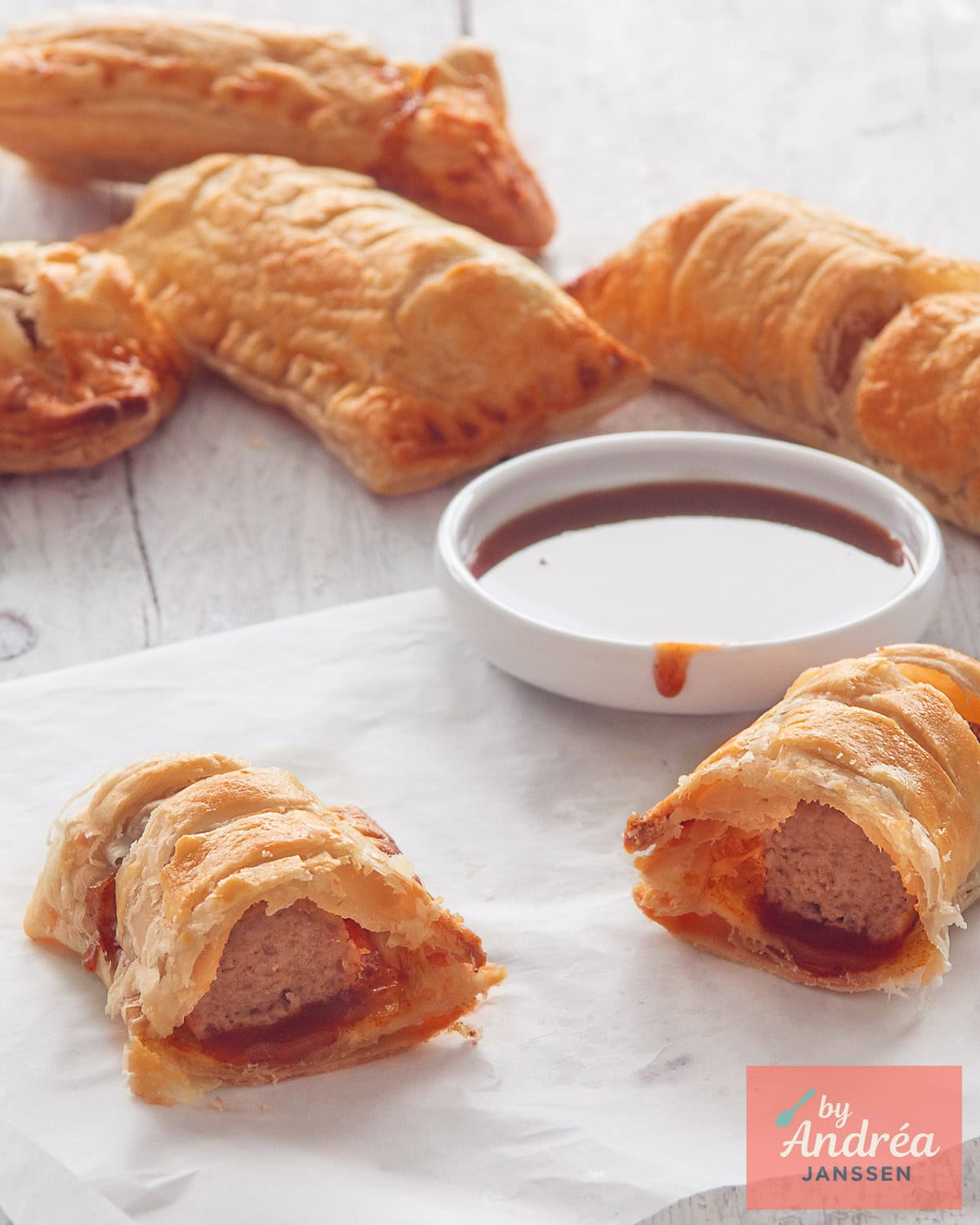 A white background with frikandel rolls. A frikandel roll with a frikandel is visible in the front.