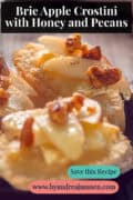 A portion of a black dish with baguettes, brie, apple, walnut, and honey. A caption reads: Brie Apple Crostini with Honey and Pecans.