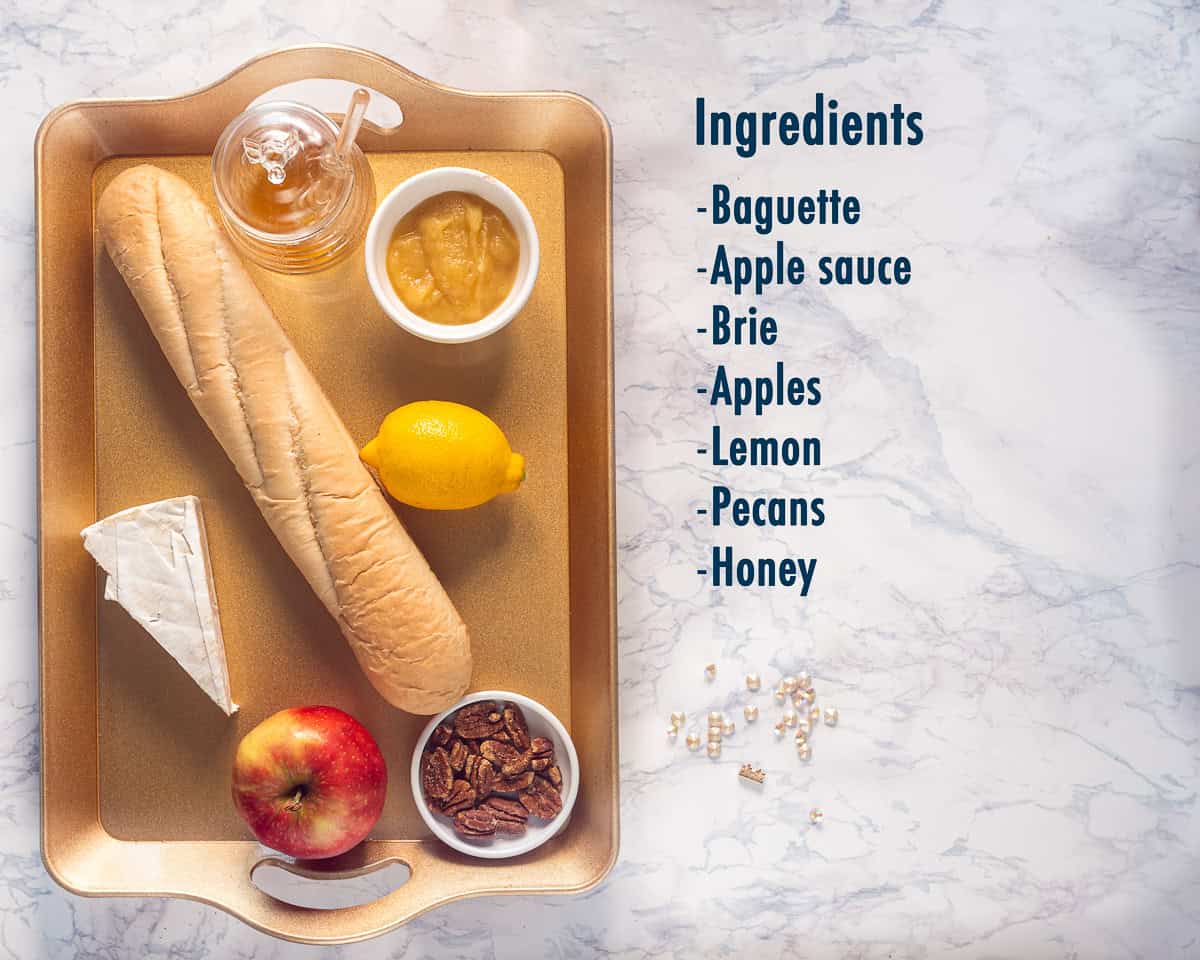 Ingredients Brie Apple Crostini With Honey And Pecans on a golden tray with on the right a text description