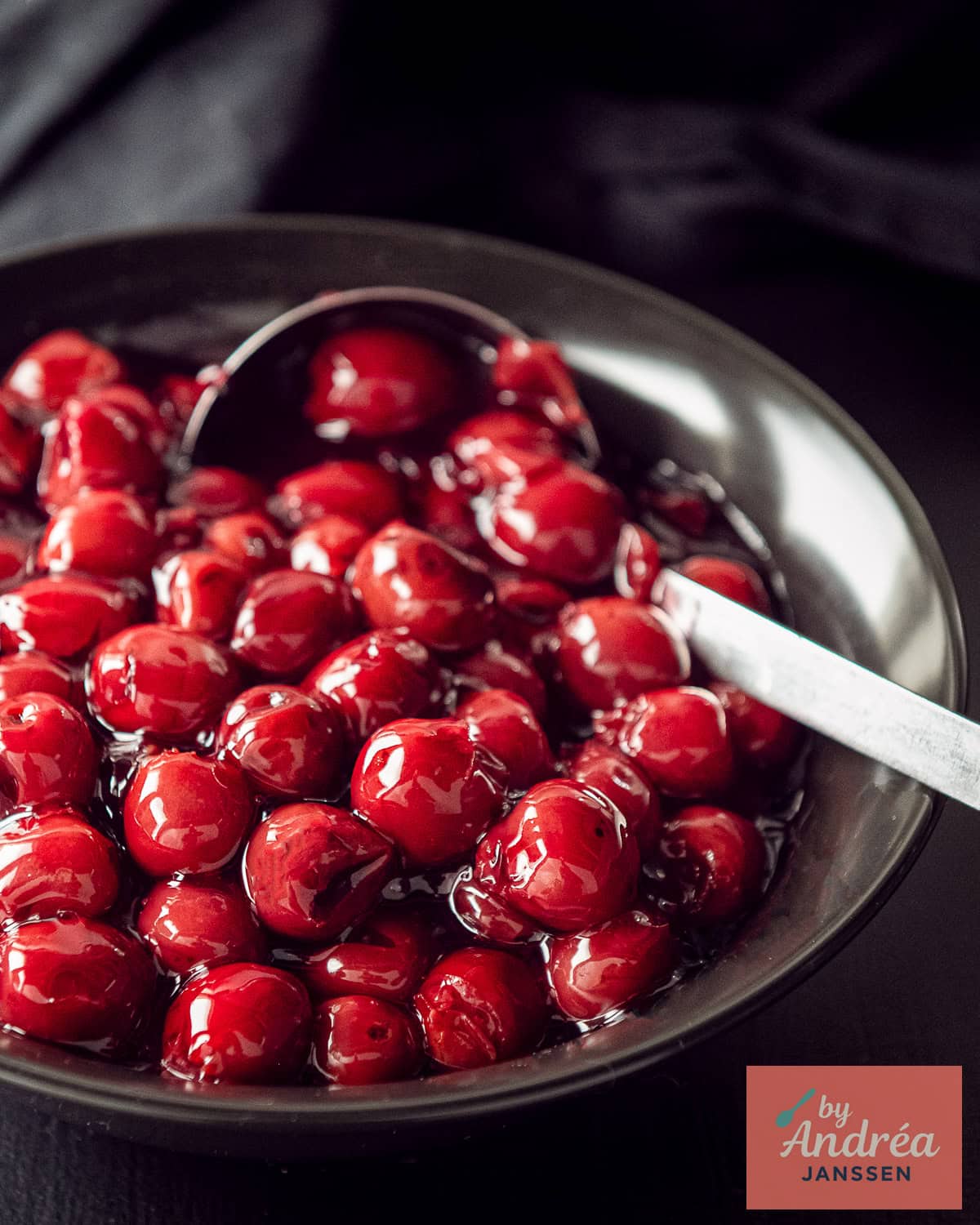 A black bowl with cherry filling for pie.