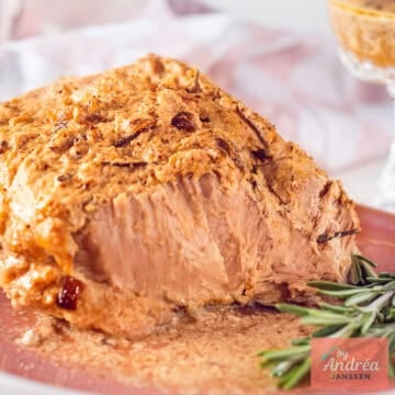 Slow cooker pork rollade served on a pink plate