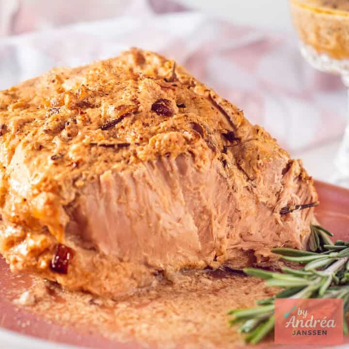 Slow cooker pork rollade served on a pink plate