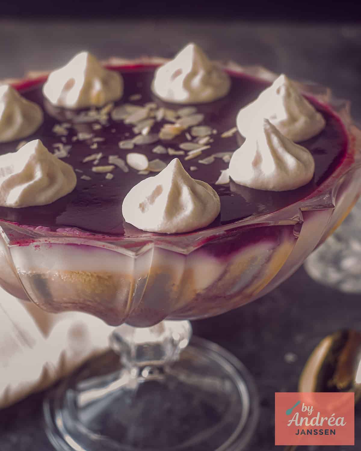 A trifle dish with trifle with red fruit, custard and sherry.