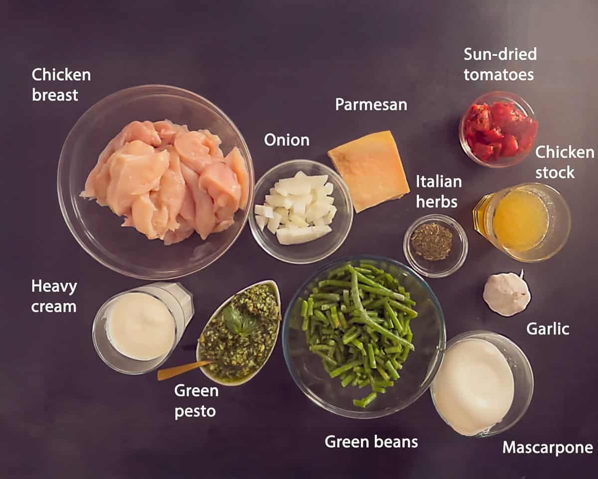 Ingredients slow cooker tuscan chicken with pesto and cream on a dark background with text description.