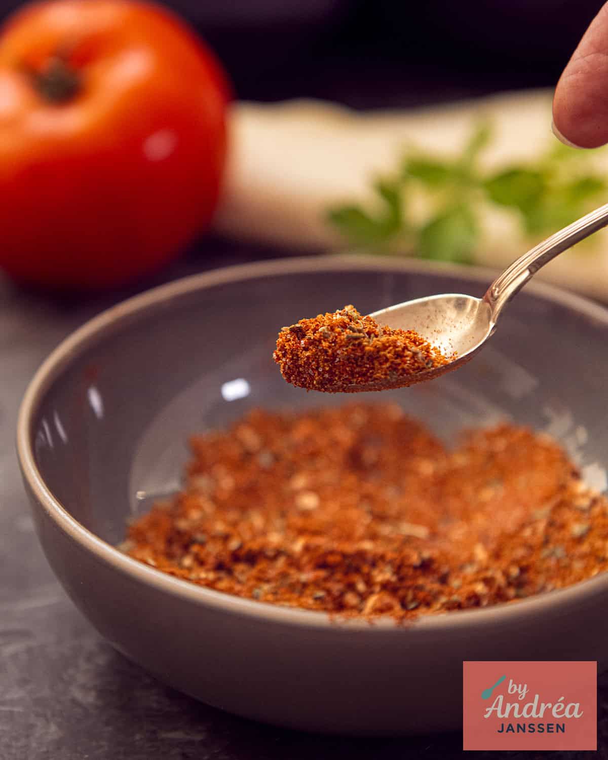 A spoon holds up spices from the burrito spice mix