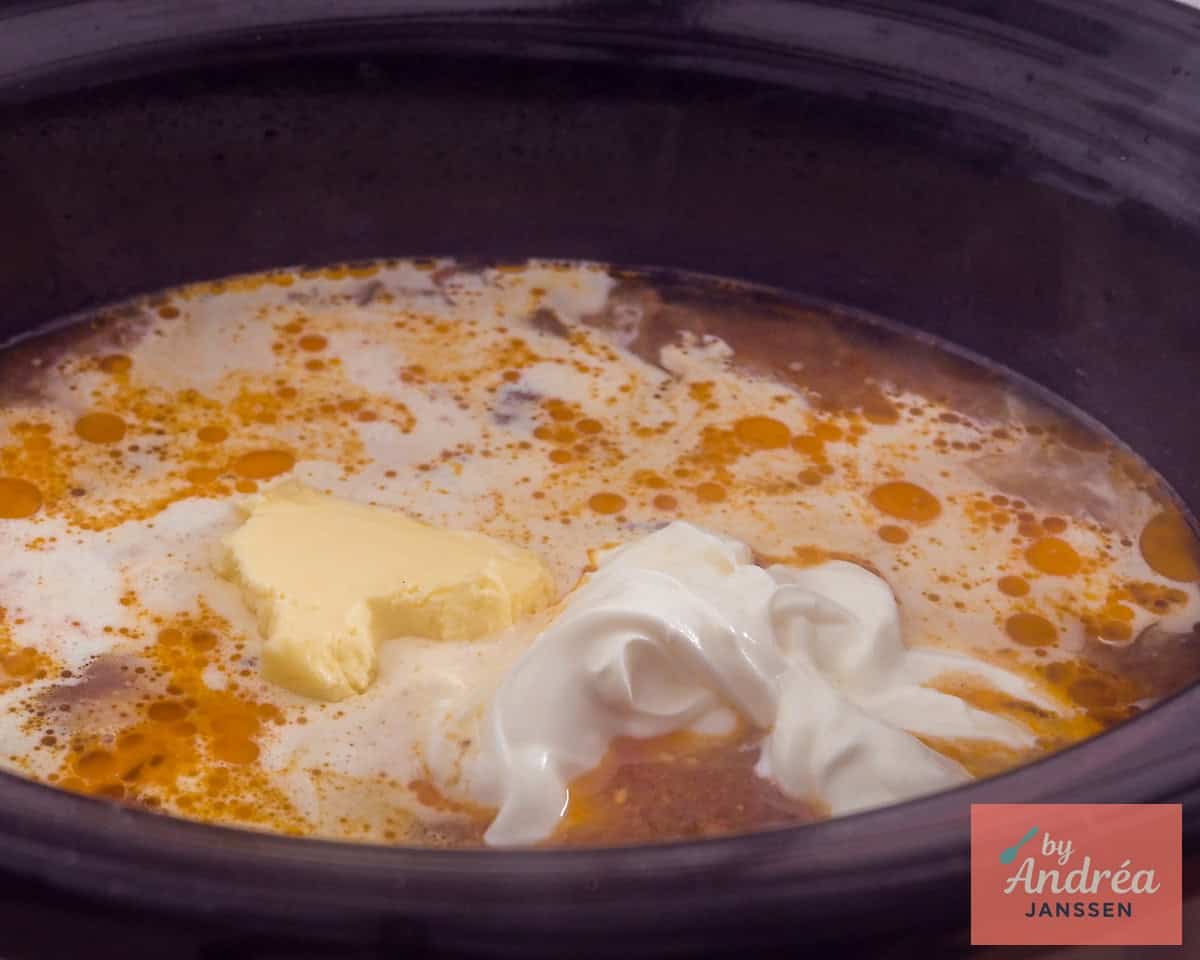 Cream, butter, and sour cream added to the slow cooker.