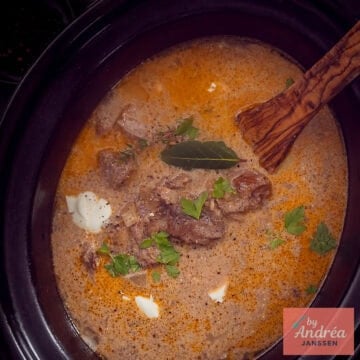 A square photo of part of a slow cooker filled with beef stroganoff.