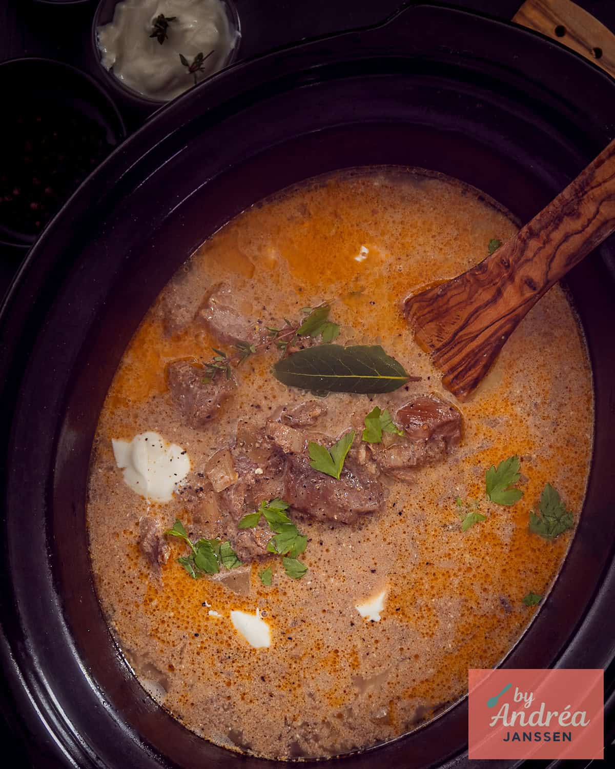 A slow cooker filled with stroganoff in a creamy sauce.