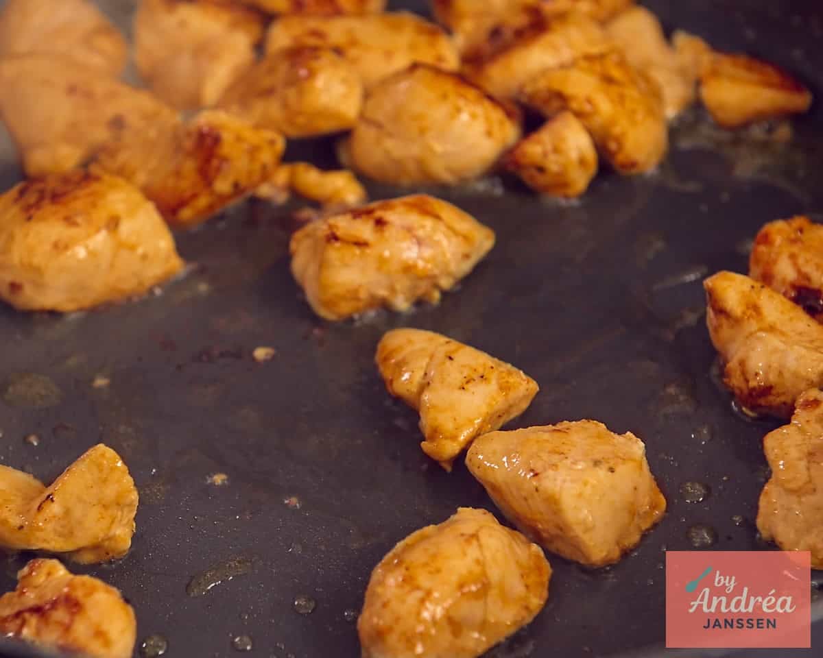 Chicken cubes browned in a frying pan