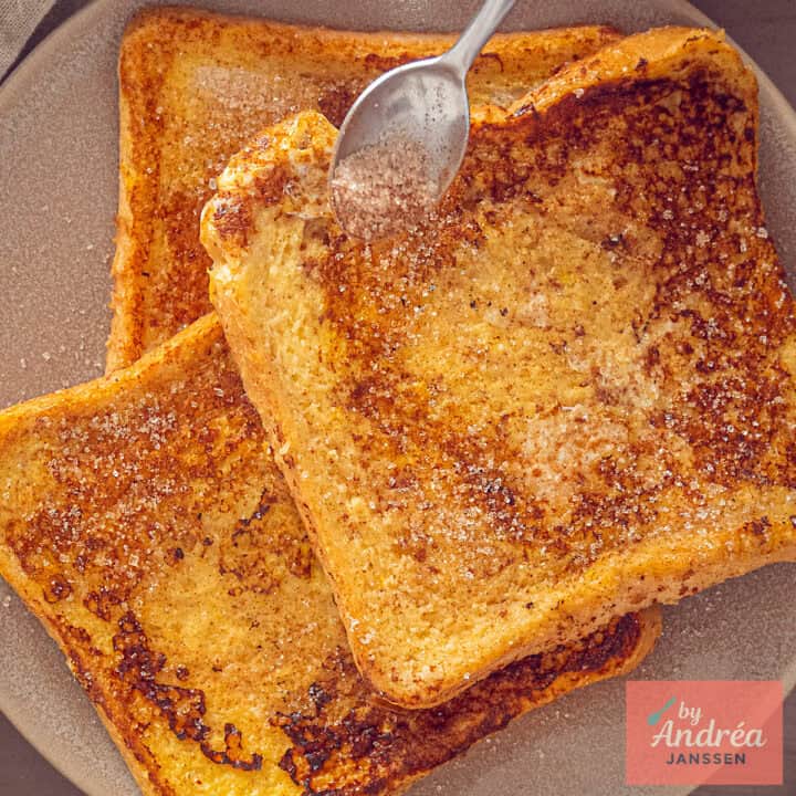 A square photo with classic French toast sprinkled with cinnamon sugar