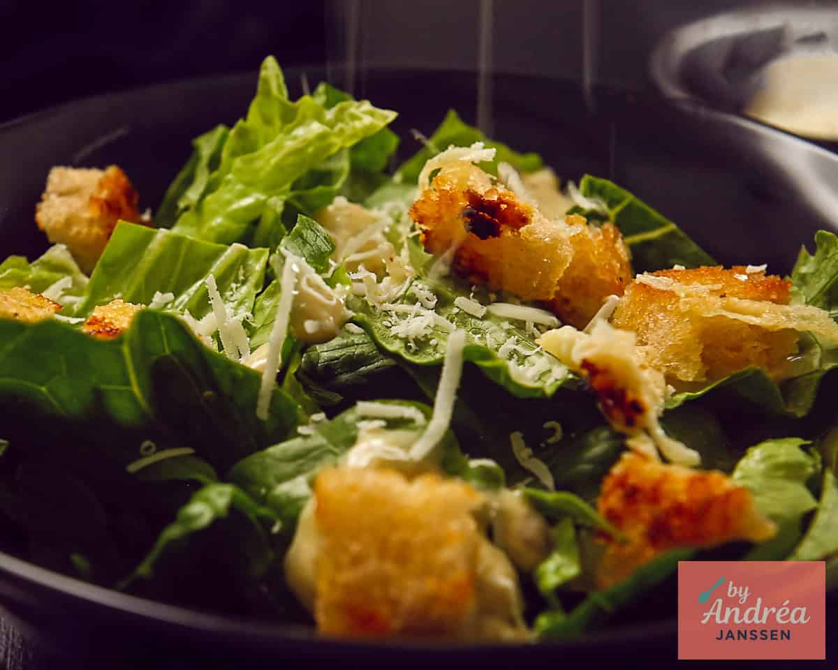 Grate Parmesan cheese over the Caesar Salad