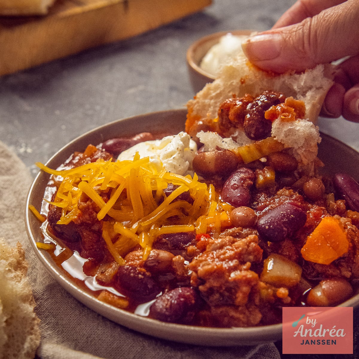 Crusty bread dipped into chili con carne with cheddar and sour cream.