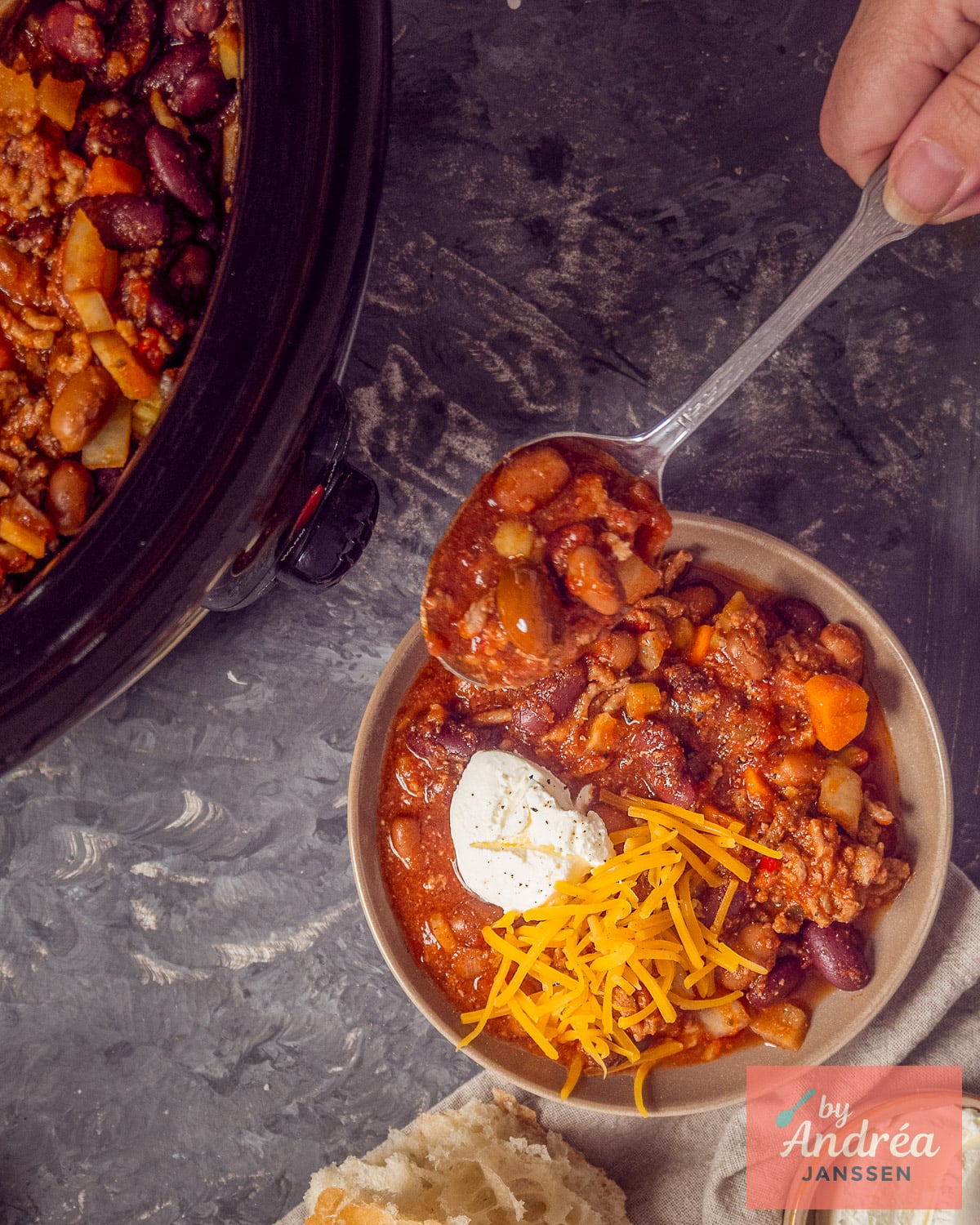 Chili con carne spooned from the slow cooker into a serving bowl.