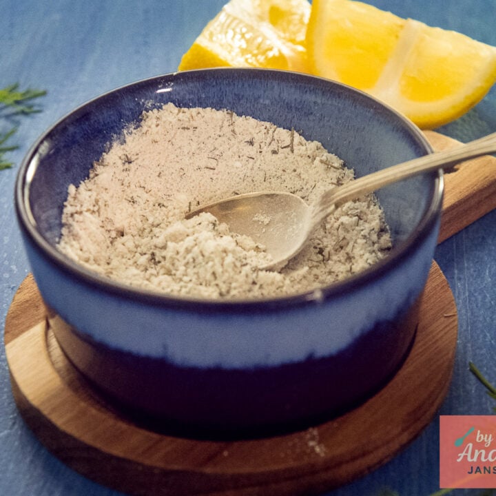Homemade Dutch fish seasoning with dill and parsley in a blue bowl