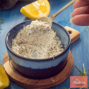 Close-up of a spoonful of homemade fish seasoning with dried dill and parsley