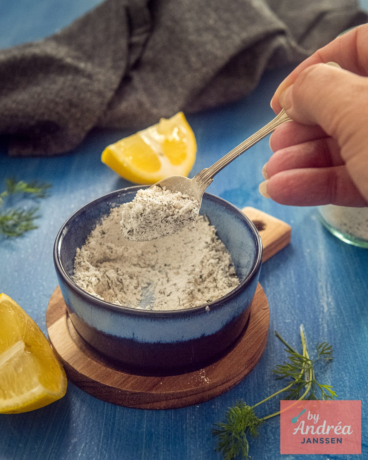 Close-up of a spoonful of homemade fish seasoning with dried dill and parsley