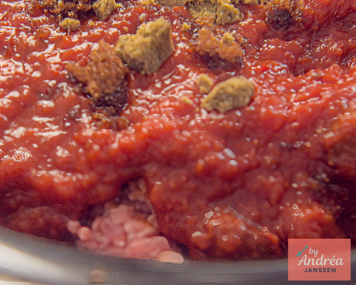 Tomatoes and seasonings added to ground beef in the slow cooker.